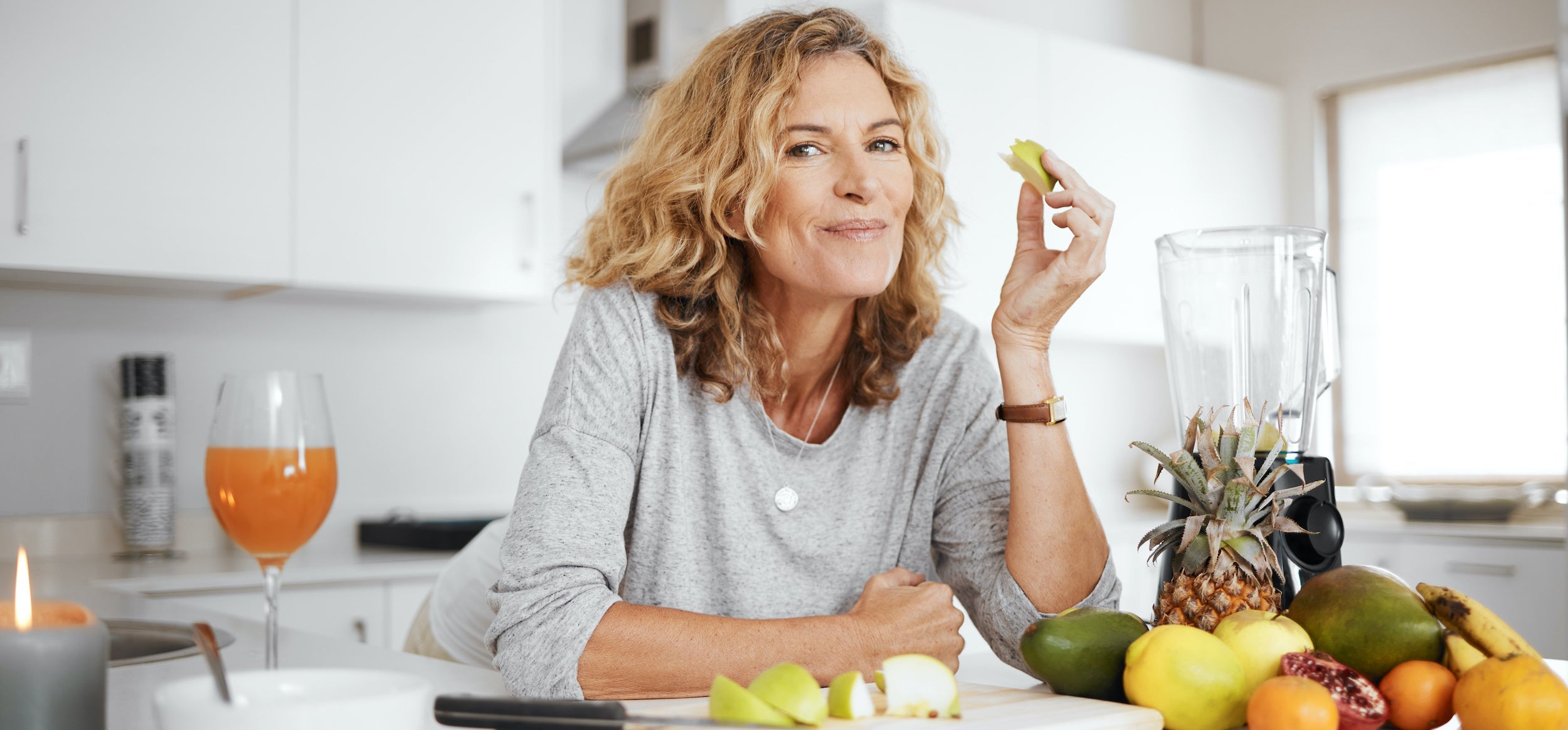 Woman in the kitchen eating healthy fruits