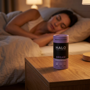 Person sleeping in bed with a Halo Dream supplement container on a nightstand.
