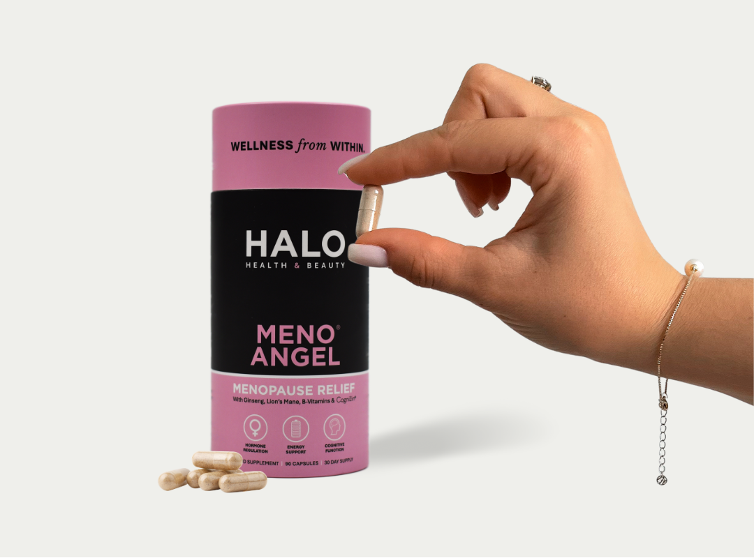 Hand holding a Halo Meno Angel supplement canister with pink and black design on a white background